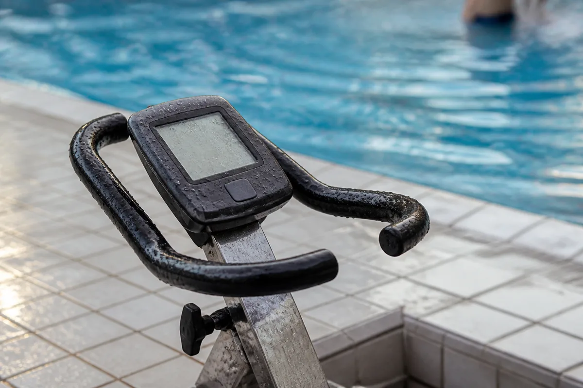 Compteur de vélo aquatique et bord de bassin carrelé, gouttes d&rsquo;eau, faible profondeur de champ